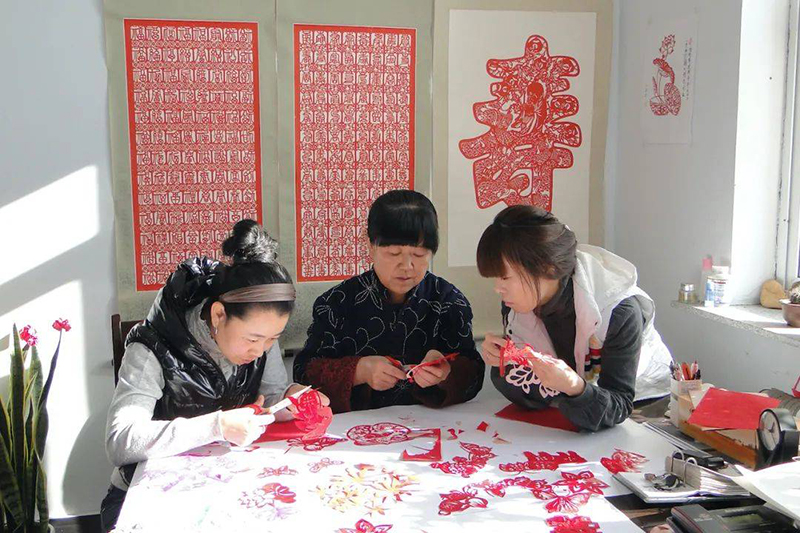 2020年11月10日西丰满族剪纸市级代表性传承人王艳春在家中传授剪纸技艺（摄影：李忠杰）.jpeg